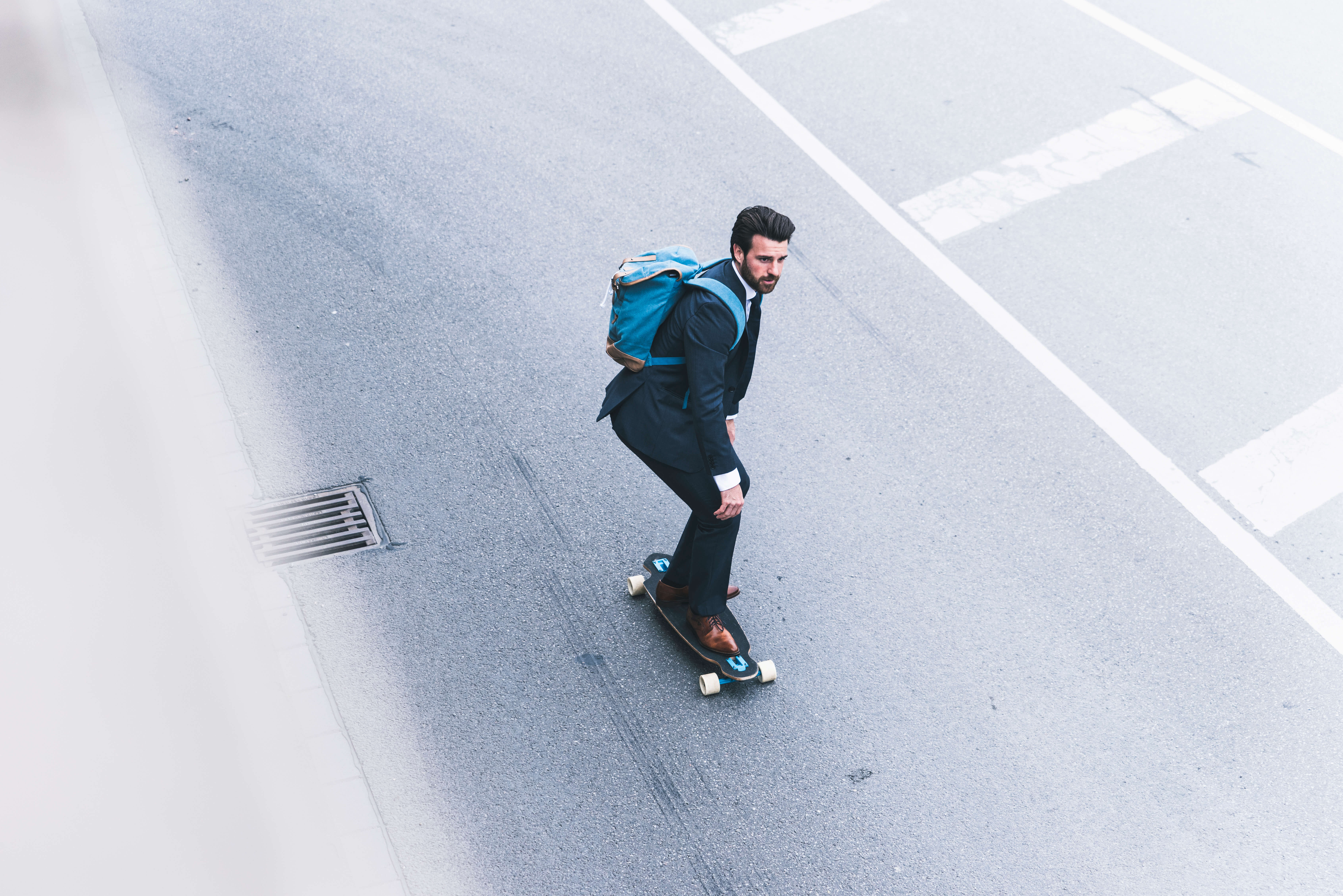 Mann mit Anzug auf Skateboard