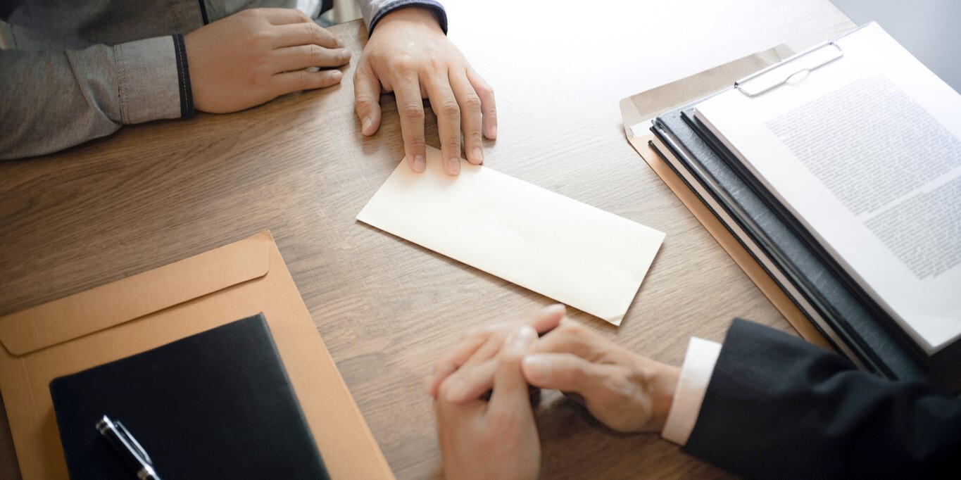 Mann mit Kündigungsbrief für kündigte an human resources manager, zu sehen ist der Schribtisch mit dem Brief und die Hände der Männer