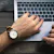 Hand mit Armbanduhr auf Laptoptastatur
