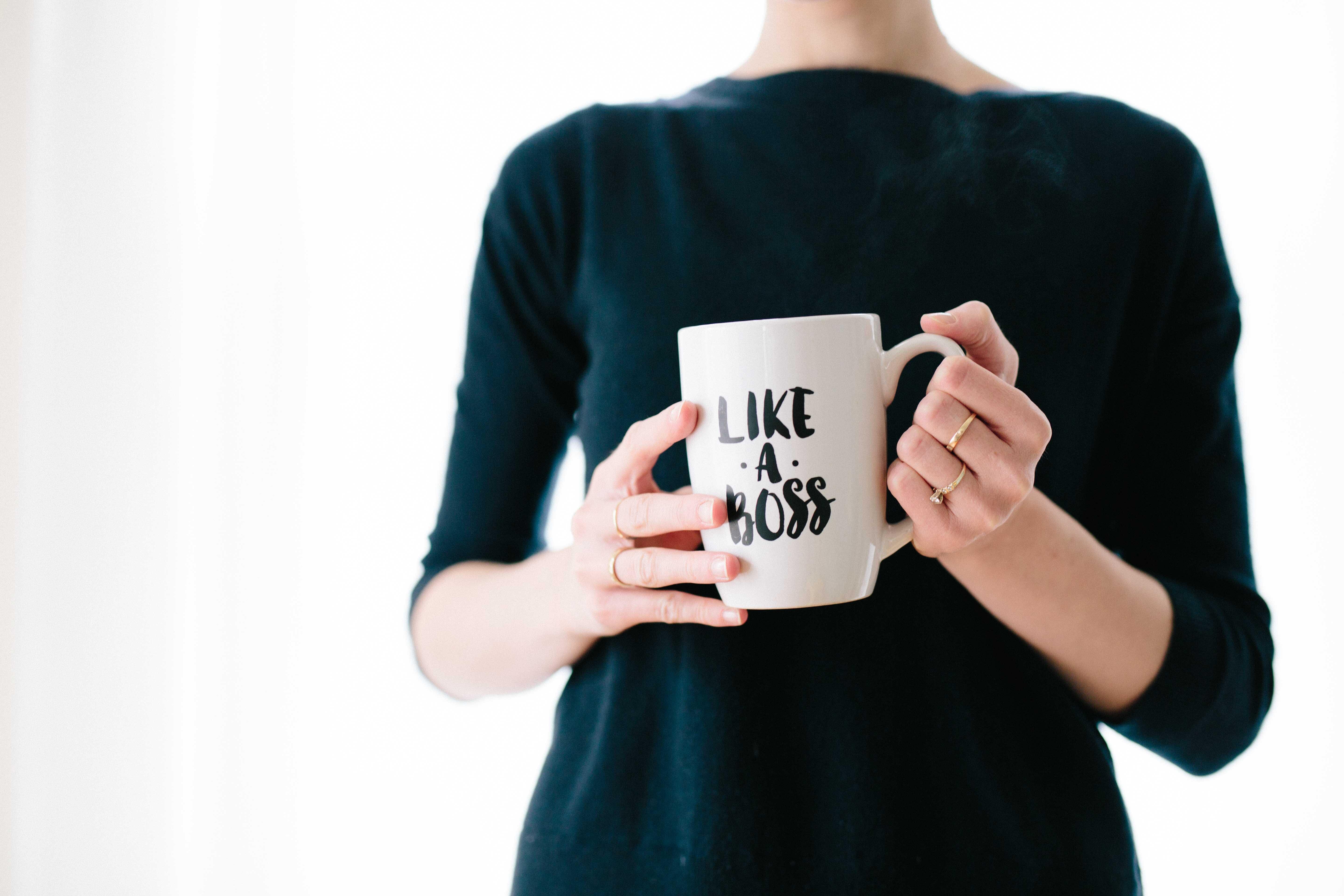Frau hält Tasse mit Aufschrift Like a Boss